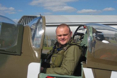 Comedian Al Murray sitting in Supermarine Spitfire at Duxford
